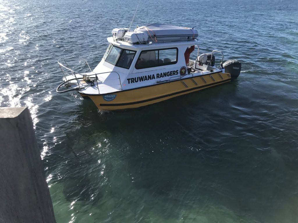 A small vessel that has a yellow hull with a white top and has Truwana Rangers labelled down the side.